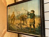 a painting on the wall of a room with a painting of a man shooting a gun