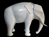 a white elephant that is standing on a black surface