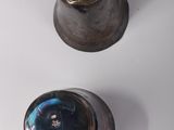 two silver vases sitting on a white surface