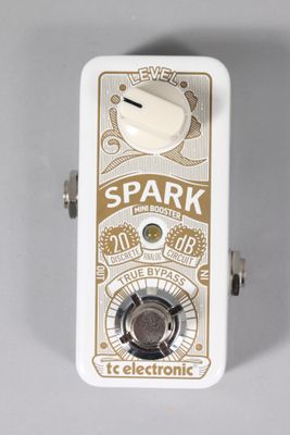 a close up of a white and gold electric guitar pedal over a white background