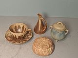 four different pieces of pottery sitting on a table