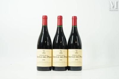three bottles of red wine sitting on top of a white table