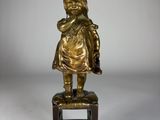 figurine en laiton représentant un enfant assis sur un tabouret