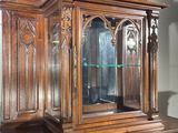 a large wooden cabinet with a glass door on top of it