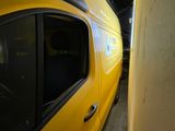 a yellow van parked next to a wall in a garage