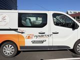 une camionnette blanche garée sur un parking à côté d'un bâtiment