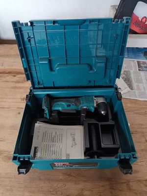 une boîte à outils bleue contenant des outils, posée sur une table en bois