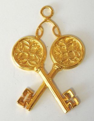 two gold keys with a medallion on them are attached to a gold chain