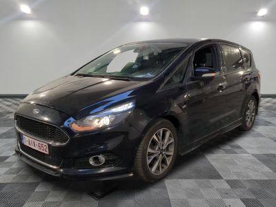 a black car is parked in a room with a checkered floor