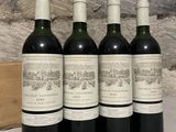 four bottles of wine are lined up on a table