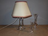 une lampe posée sur une table à côté d'un vase en verre