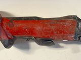 a red and black pipe cutter on a white surface