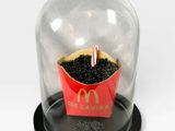 a mcdonald ' s cupcake under a glass dome on a table
