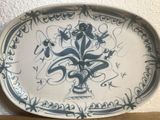 a blue and white plate with a flower design on it