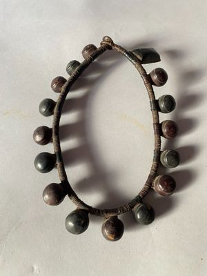 a close up of a bracelet with beads on a white surface