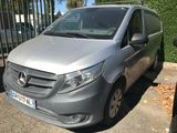 a silver van parked in a parking lot next to a fence