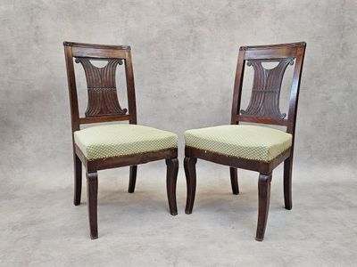 deux chaises en bois aux assises rembourrées vertes, sur fond blanc