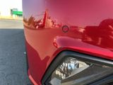 a close up of a red car ' s headlight on the street