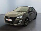 La voiture grise est garée dans une grande pièce au sol noir.