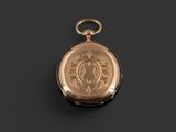 an antique gold pocket watch with a chain on a black background