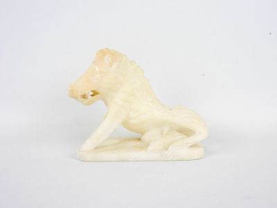 une figurine en ivoire représentant un lion assis sur ses pattes arrière