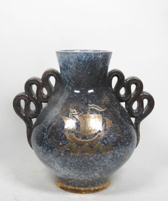 un vase bleu avec une anse dorée sur fond blanc