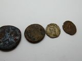 un groupe de cinq pièces de monnaie anciennes posées sur une surface blanche