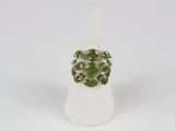 a close up of a ring with green stones on it