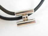 a black leather cord with two silver beads on it