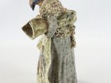 figurine of a woman in a white dress with a blue hat and scarf