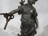une statue représentant une femme tenant une clé à la main