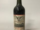 a bottle of red wine sitting on top of a white table