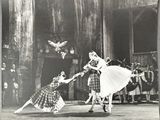 black and white photograph of a couple of dancers performing in front of a group of people
