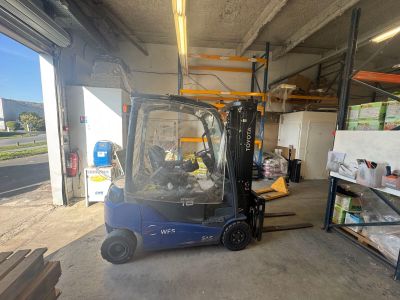 a blue fork truck parked in a warehouse