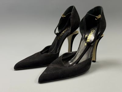 a pair of black high heeled shoes on a white surface