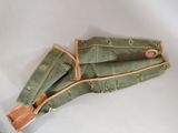 pair of green canvas umbrellas with leather handles on a white surface