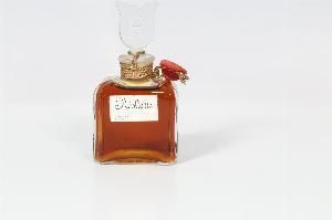 un petit flacon de parfum orné d'une fleur rouge