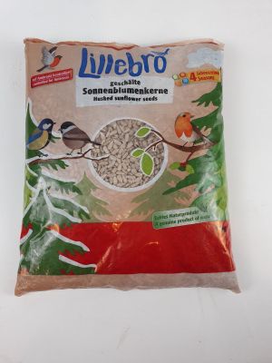 un gros plan d'un sac de graines pour oiseaux posé sur une surface blanche