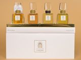three bottles of perfume sitting on top of a white box