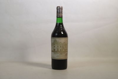 une vieille bouteille de vin posée sur une table blanche