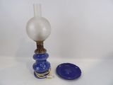 une lampe bleue et blanche et une assiette bleue posées sur une table blanche