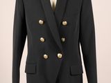 un costume noir avec des boutons dorés sur le revers