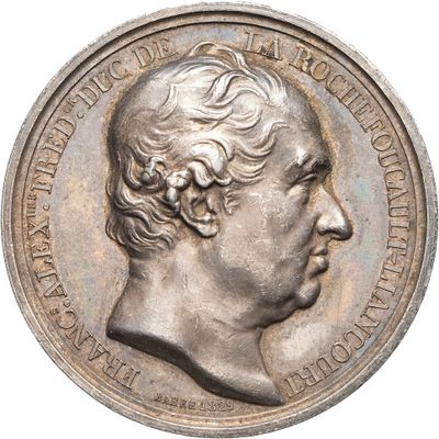 une vieille médaille d'argent avec un visage d'homme dessus