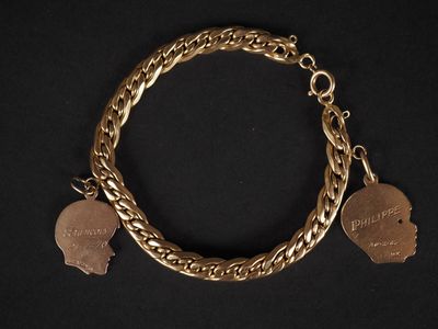 un gros plan d'un bracelet en or orné de deux breloques