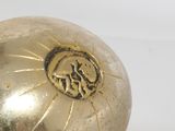 a gold ball with a lion on it on a white surface