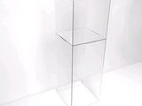 une vitrine transparente avec un couvercle en verre, posée sur un plan de travail blanc