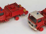 deux camions de pompiers miniatures posés côte à côte sur une surface blanche