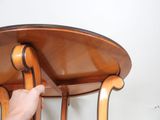 a hand that is holding a wooden table with a glass top