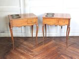 two small tables with bowls on them on the floor