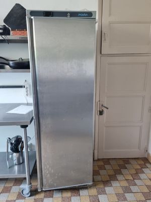 a stainless steel refrigerator in a kitchen with a checkered floor